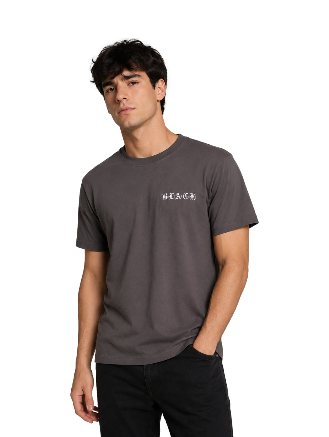 Hombre vistiendo una playera de manga corta color gris oscuro con un pequeño texto blanco en el pecho.