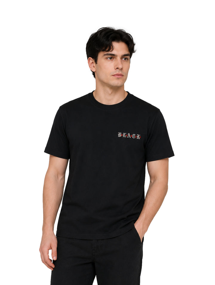 Hombre vistiendo una playera negra de manga corta con un pequeño detalle de texto en el pecho.