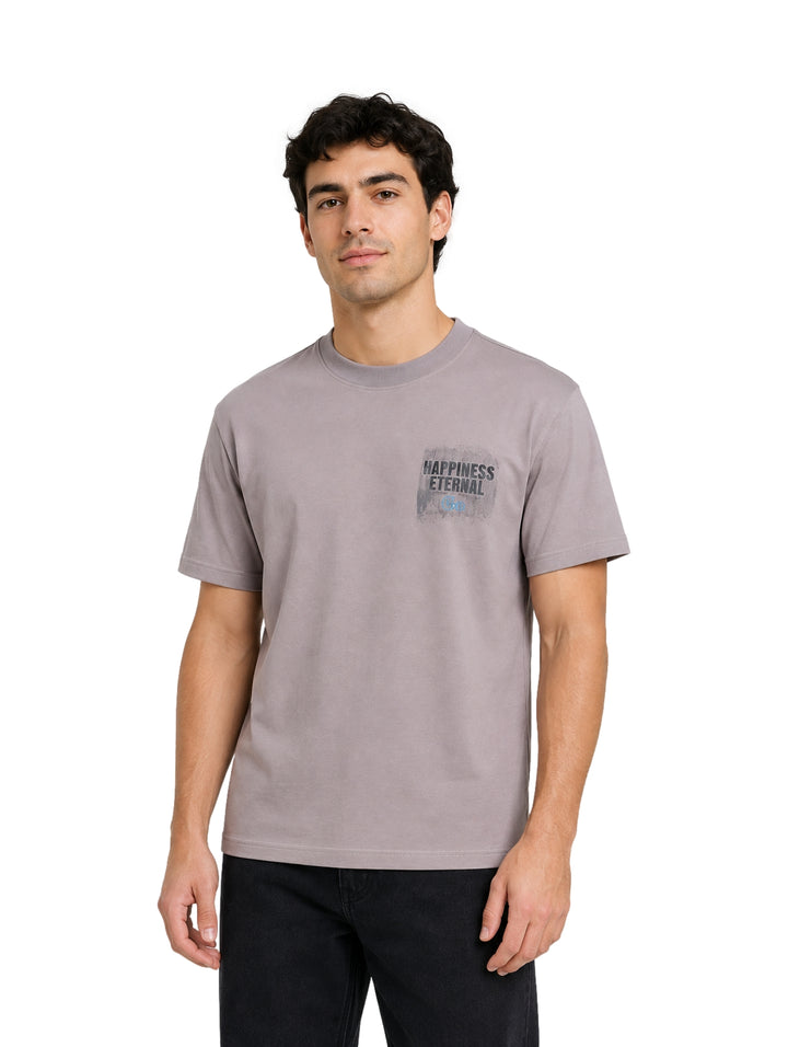 Hombre vistiendo playera de color gris con estampado en el pecho.