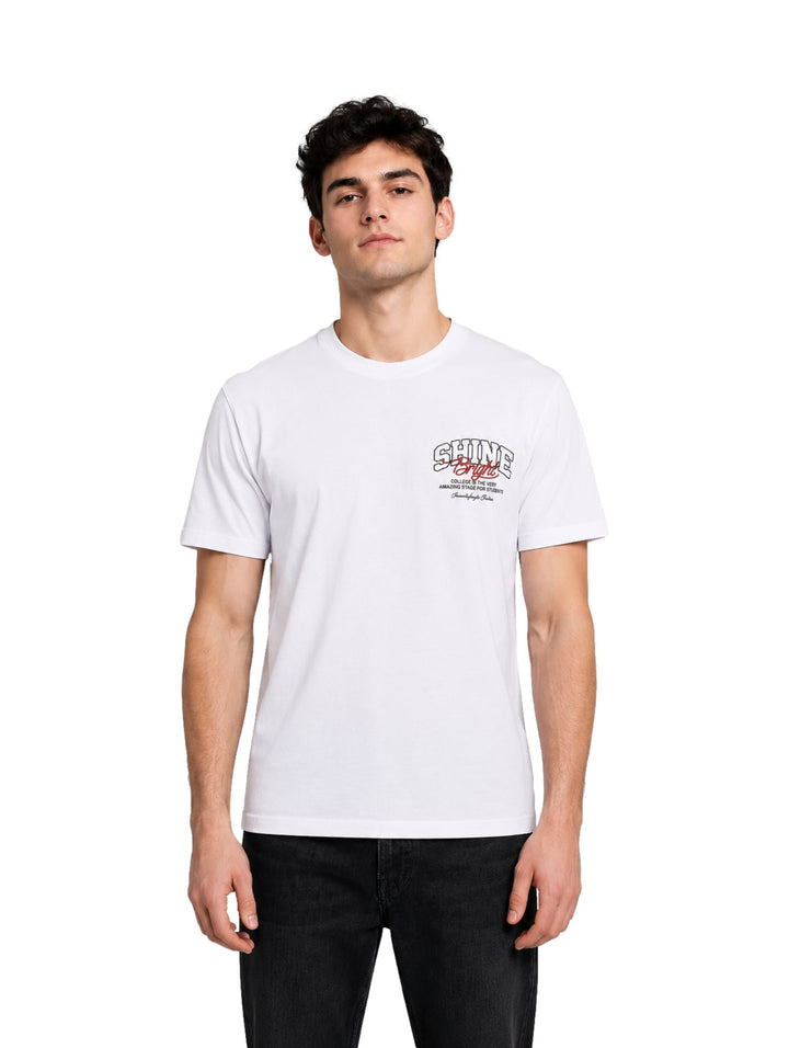 Hombre vistiendo una playera blanca de manga corta con un pequeño gráfico en el pecho.