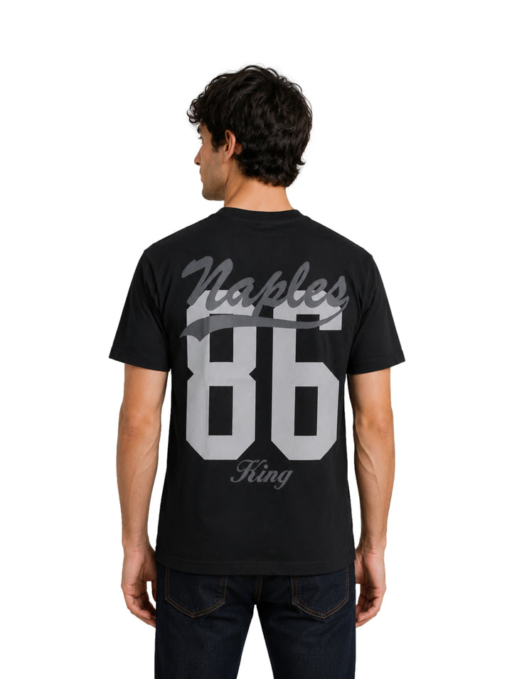 Hombre vistiendo una playera negra de manga corta con la palabra Naples en el pecho.