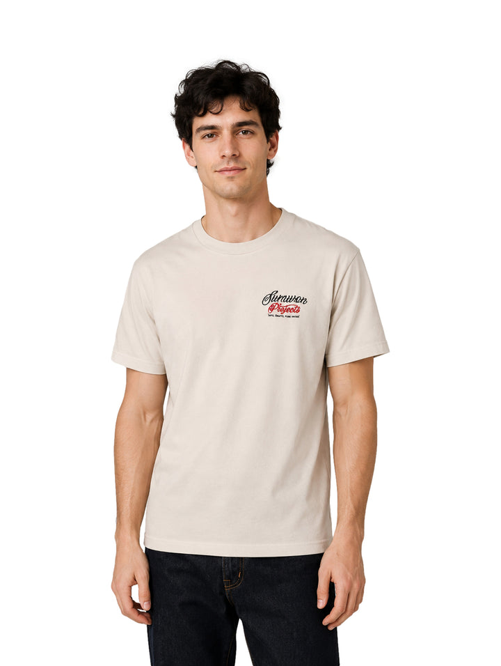 Hombre vistiendo una playera de manga corta color beige con un pequeño logotipo en el pecho.