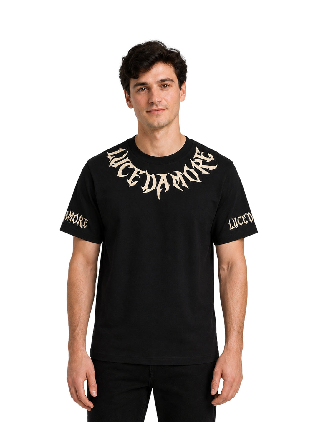 Hombre vistiendo playera negra de manga corta con letras góticas en color beige en el pecho y mangas.