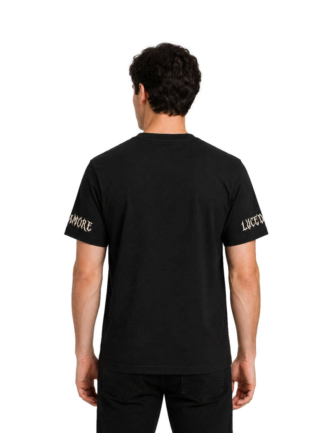 Hombre vistiendo playera negra de manga corta con letras góticas en color beige en el pecho y mangas.