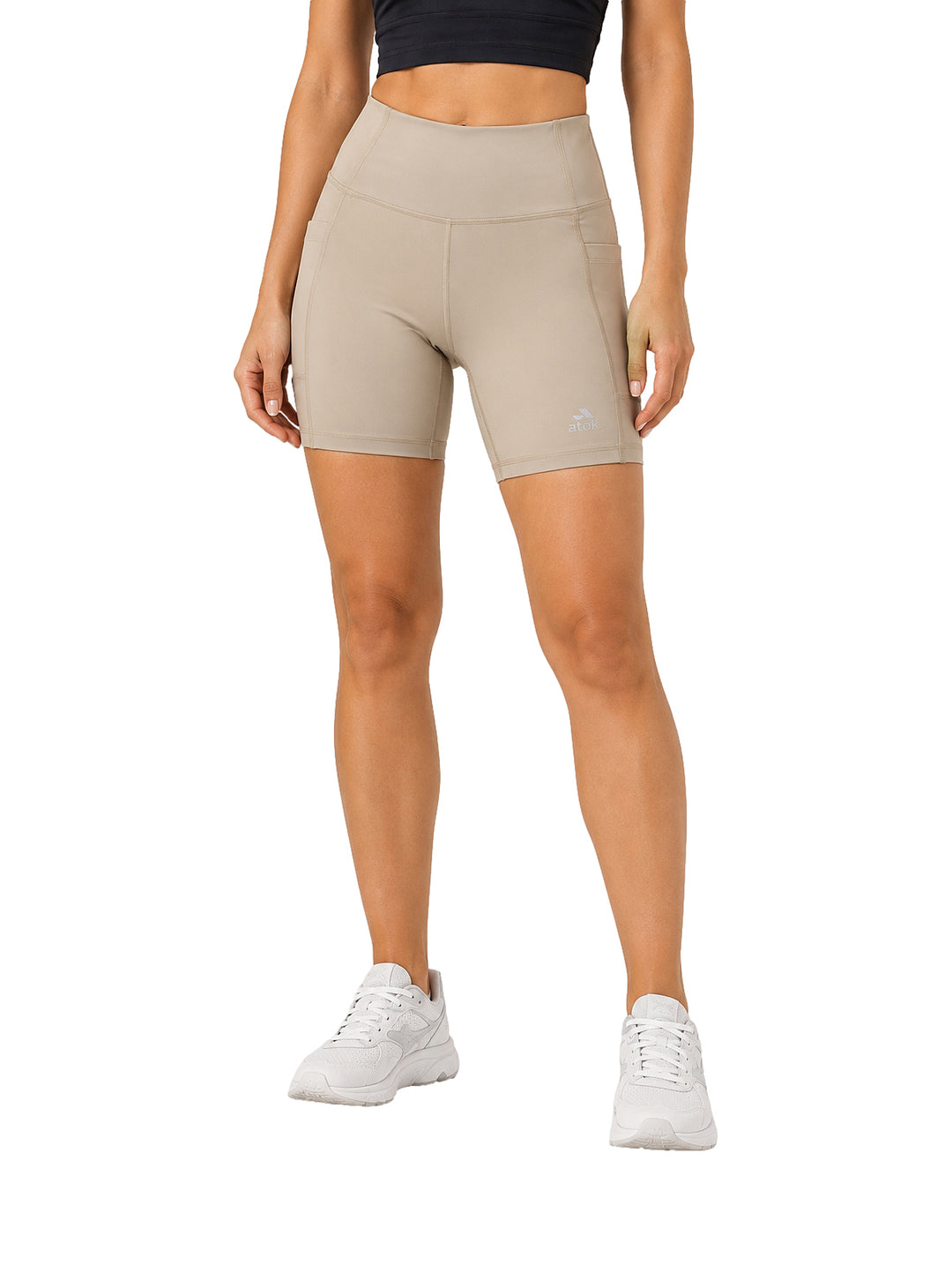 Mujer vistiendo shorts deportivos ajustados de color arena marca Atok Performance.
