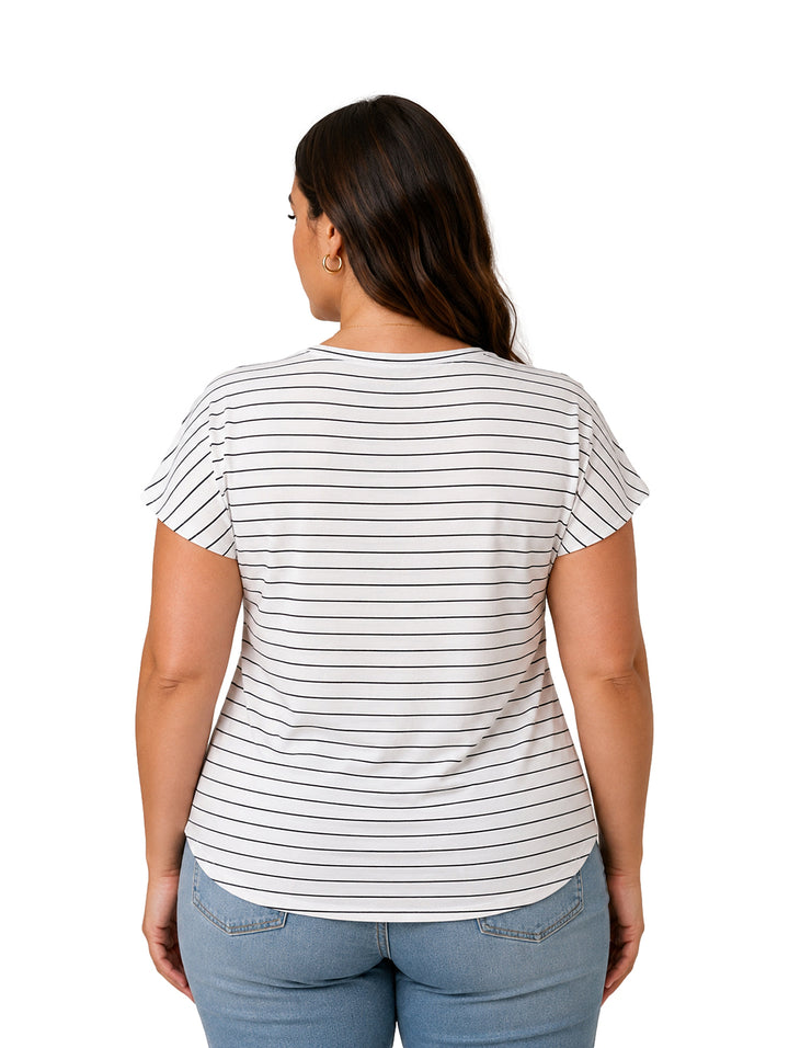 Mujer vistiendo una blusa blanca con rayas horizontales negras y pantalones vaqueros azules.