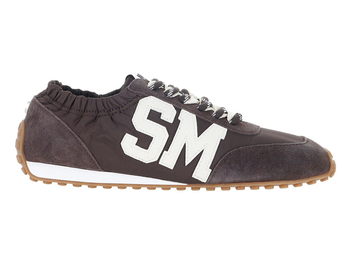 Tenis Steve Madden color chocolate con letras SM blancas y suela blanca y marrón.
