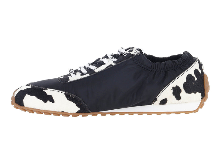 Tenis Steve Madden negros y blancos con estampado de vaca y letras SM blancas en el costado.