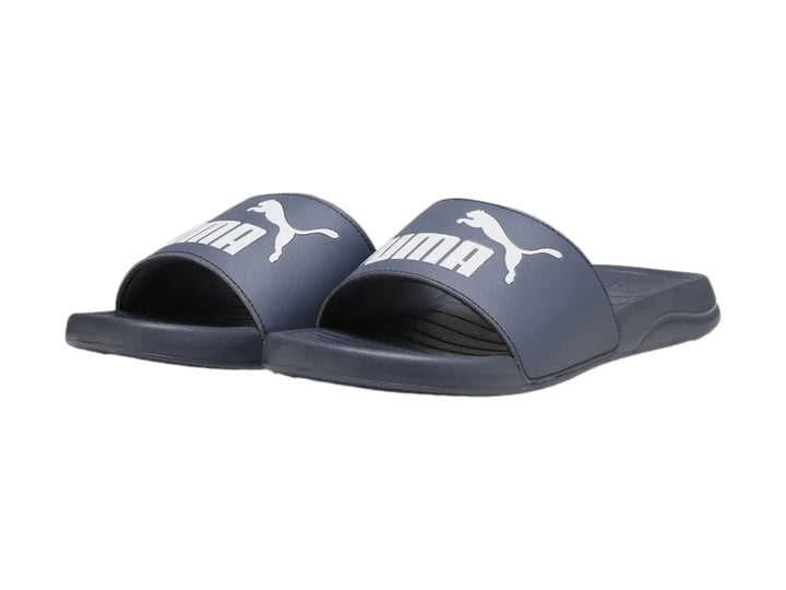Sandalia PUMA Popcat 20 color azul oscuro con logotipo blanco en la correa.