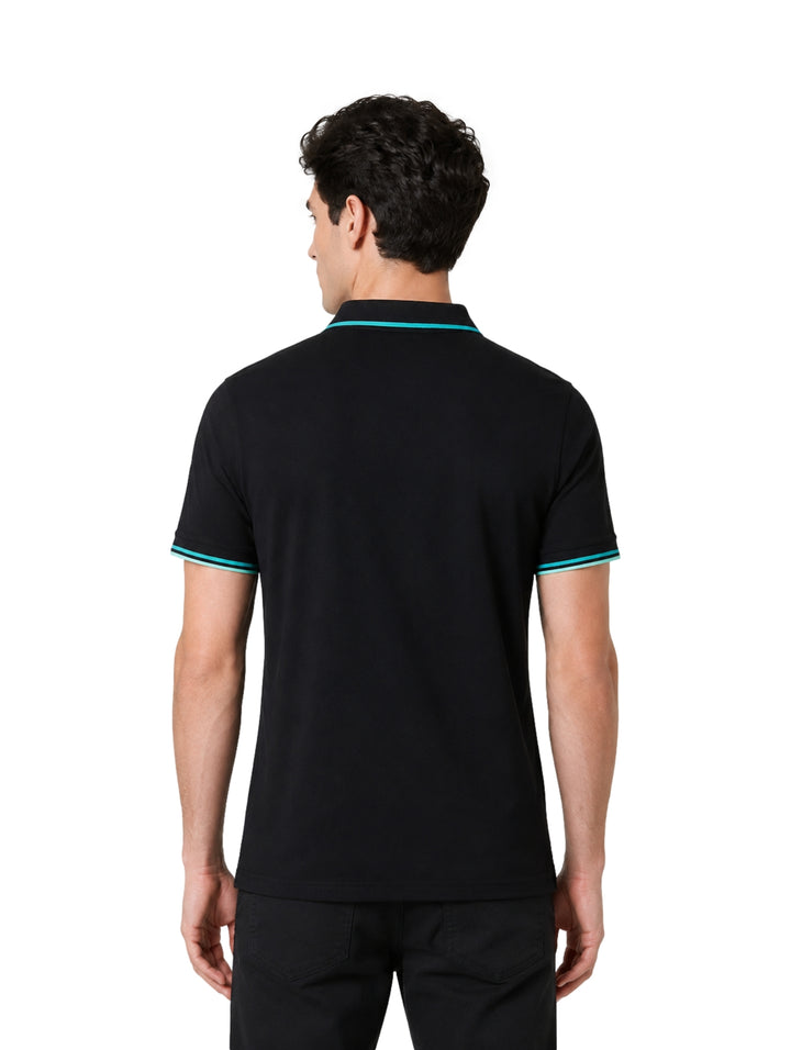 Hombre vistiendo playera polo Givenchy color negro con detalles en turquesa en cuello y mangas.