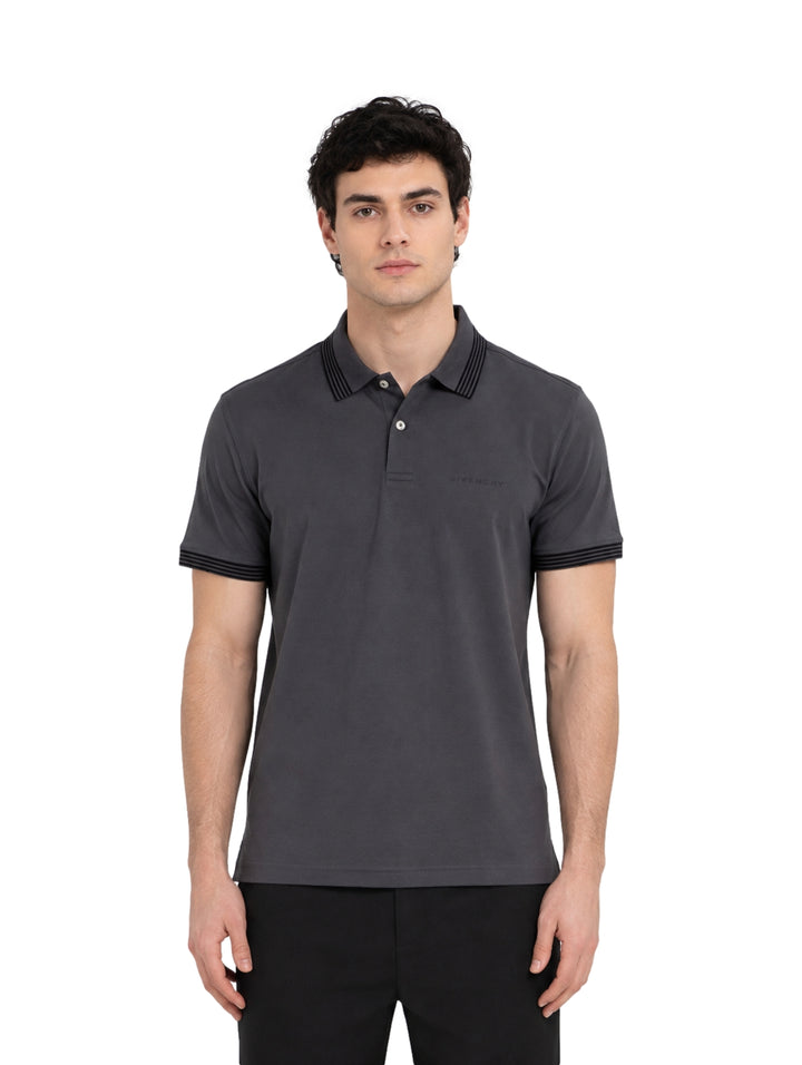 Hombre vistiendo playera polo Givenchy color gris oscuro con detalles negros en cuello y mangas.
