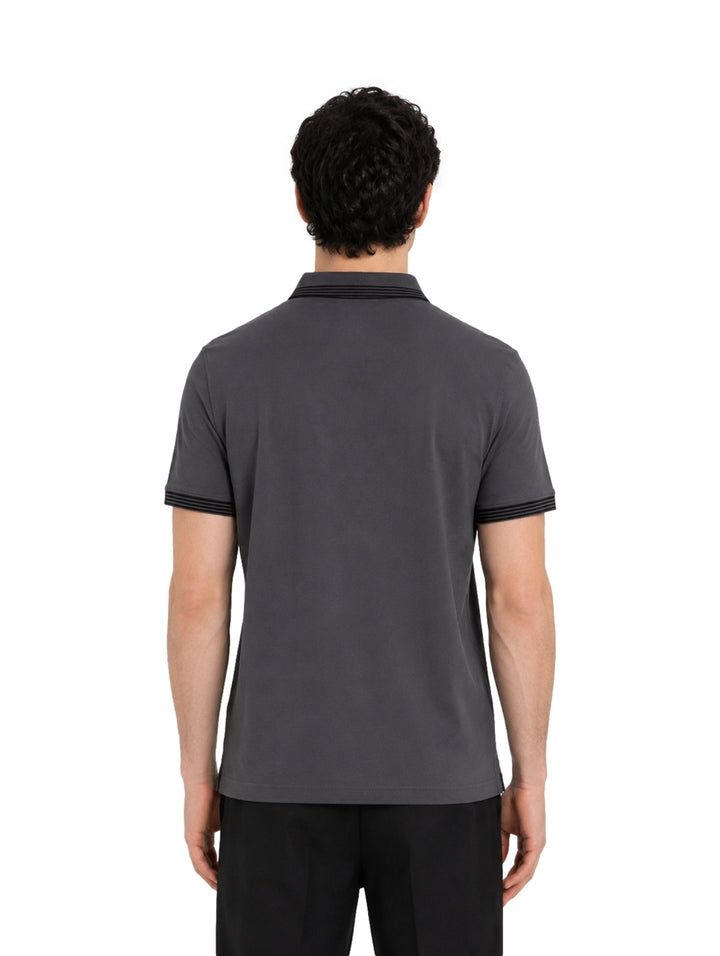 Hombre vistiendo playera polo Givenchy color gris oscuro con detalles negros en cuello y mangas.