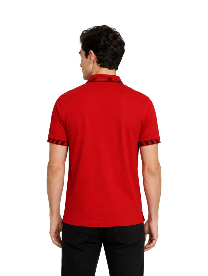 Hombre vistiendo playera polo color rojo salsa con detalles negros en cuello y mangas.