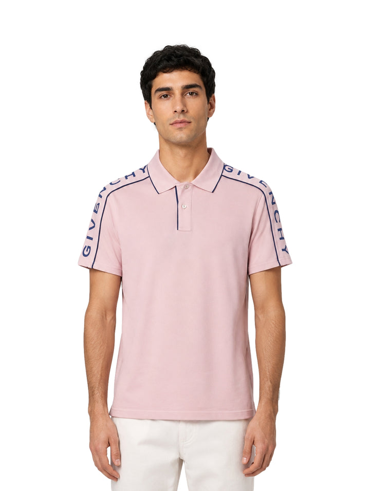 Hombre vistiendo playera polo Givenchy color lila pálido con franjas azul marino en los hombros.