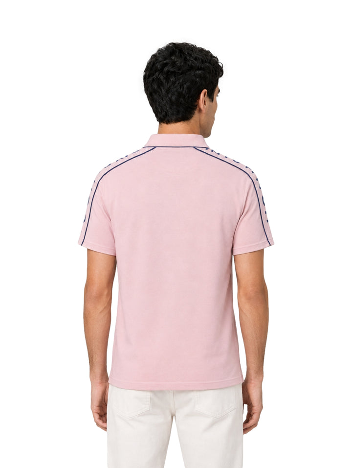 Hombre vistiendo playera polo Givenchy color lila pálido con franjas azul marino en los hombros.
