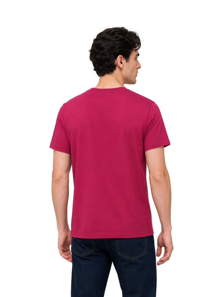 Hombre vistiendo playera Givenchy color higo de manga corta con logotipo blanco en el pecho.