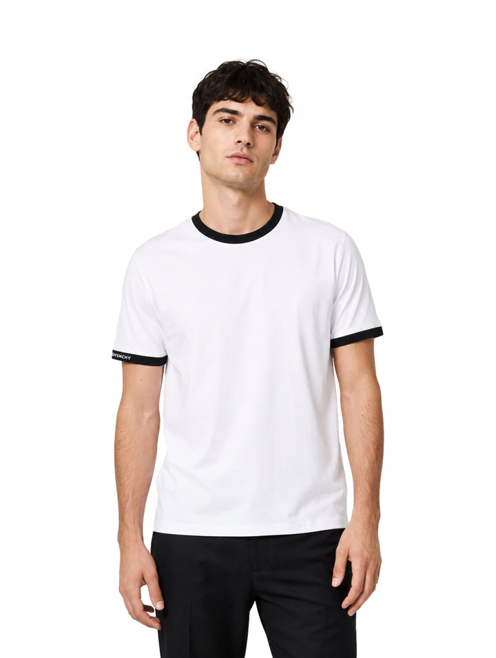 Hombre vistiendo playera blanca de manga corta con detalles negros en cuello y mangas.