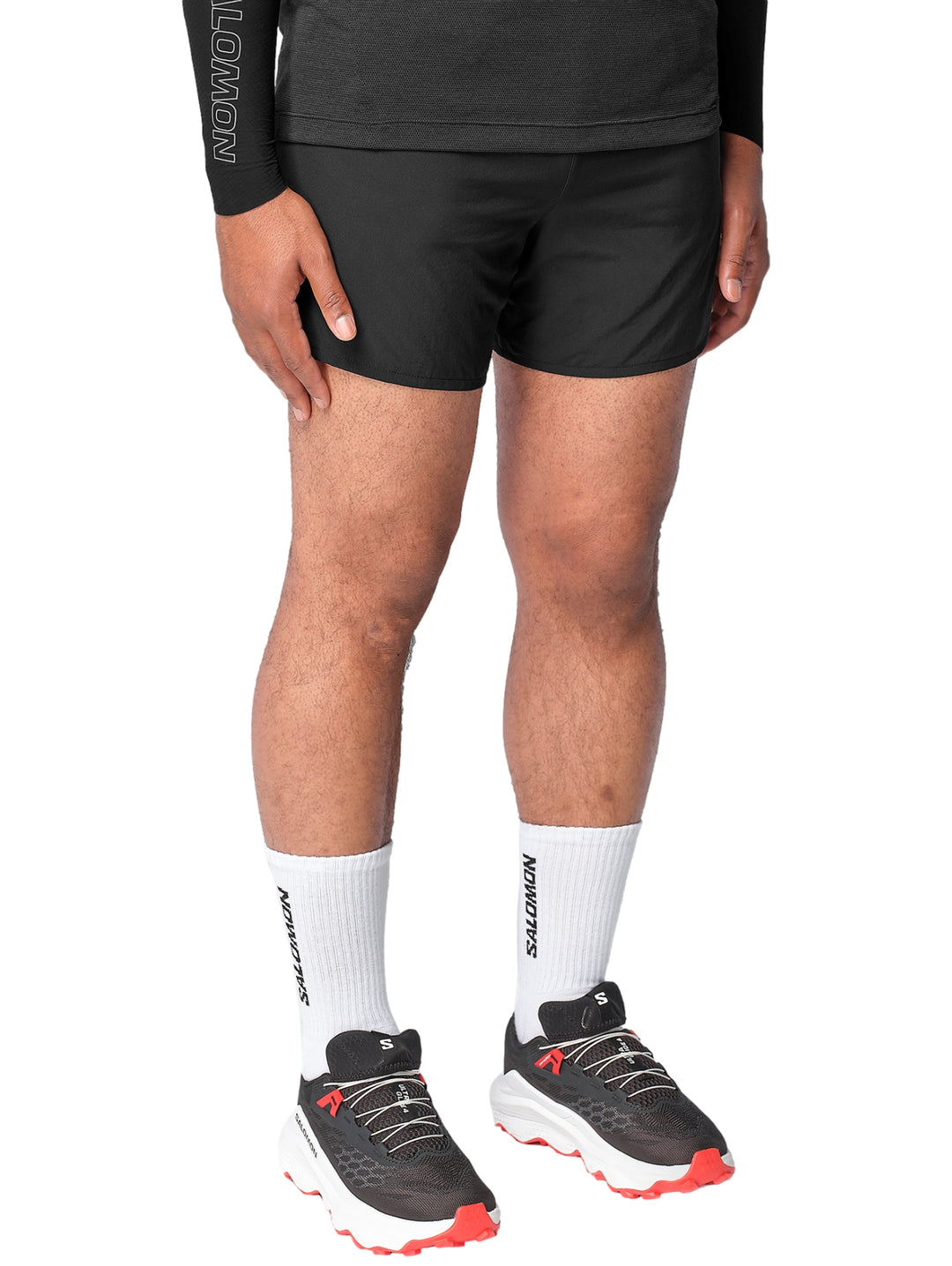 Hombre vistiendo shorts deportivos Salomon de color negro.