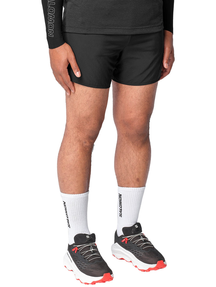 Hombre vistiendo shorts deportivos Salomon de color negro.