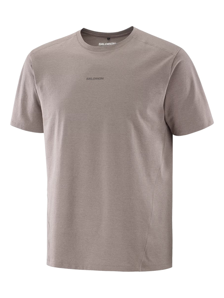 Hombre vistiendo playera deportiva Salomon de color café con manga corta.