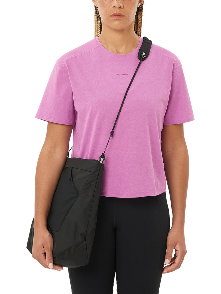 Mujer vistiendo playera deportiva Salomon de color rosa con manga corta.