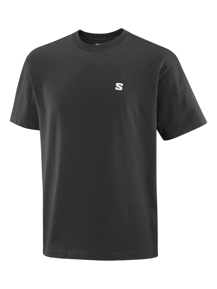 Hombre vistiendo playera deportiva negra de manga corta con logotipo pequeño de Salomon en el pecho.