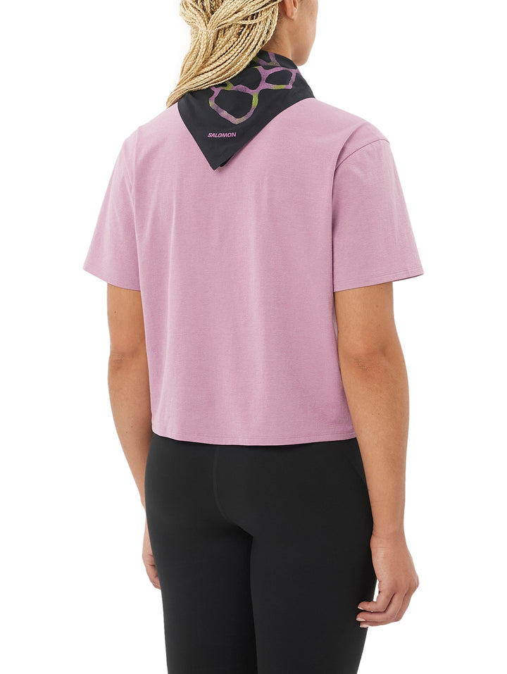Mujer vistiendo playera deportiva color rosa de manga corta y leggings negros.