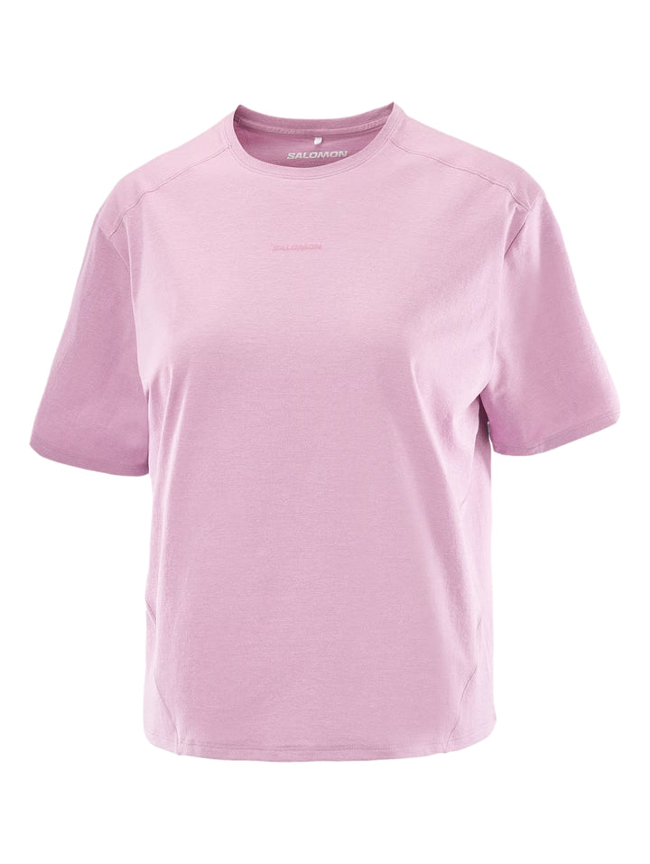 Mujer vistiendo playera deportiva color rosa de manga corta y leggings negros.