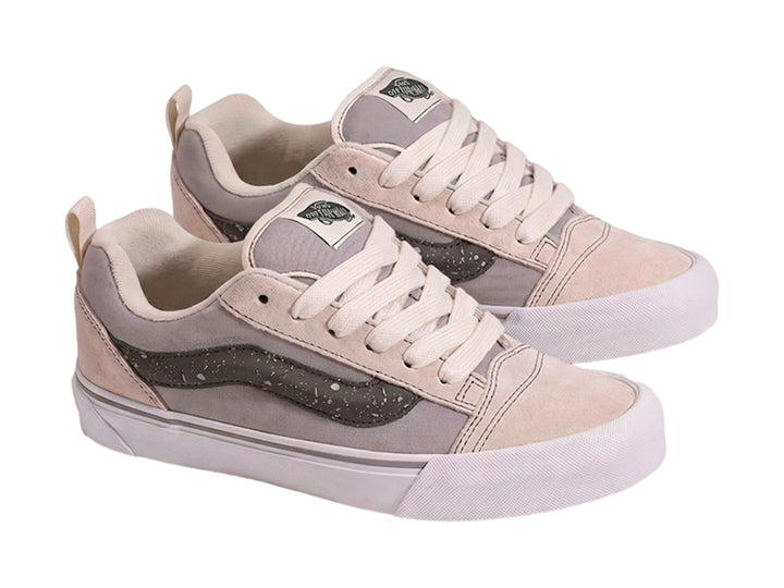 Tenis Vans Knu Skool en colores blanco hueso y gris con la clásica franja lateral en gris oscuro.