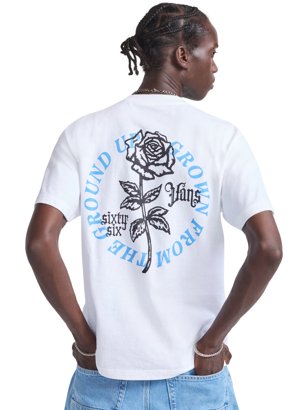 Hombre vistiendo una playera blanca de manga corta marca Vans con un logotipo azul en el pecho.