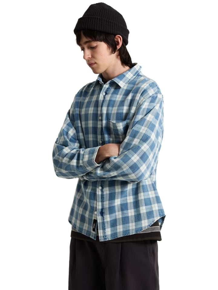 Hombre vistiendo una camisa VANS de manga larga con estampado de cuadros en color azul y blanco.