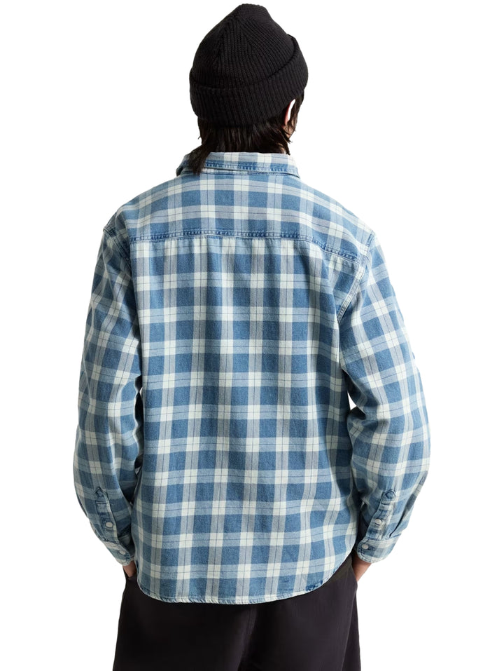 Hombre vistiendo una camisa VANS de manga larga con estampado de cuadros en color azul y blanco.