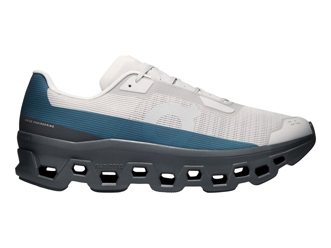 Tenis On Cloud Cloudmonster Void color plata y gris oscuro con detalles azules y suela CloudTec.