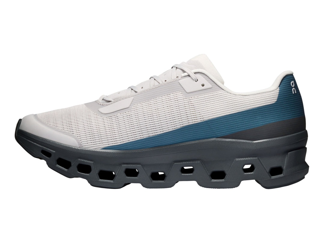 Tenis On Cloud Cloudmonster Void color plata y gris oscuro con detalles azules y suela CloudTec.