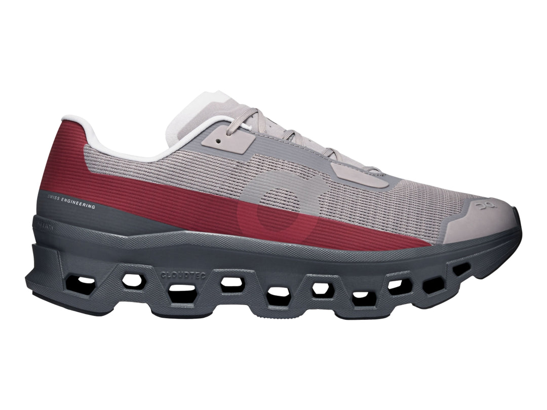 Tenis On Cloud Cloudmonster Void Eclipse para hombre en color gris con franja roja y suela oscura.