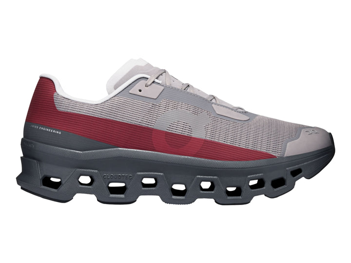 Tenis On Cloud Cloudmonster Void Eclipse para hombre en color gris con franja roja y suela oscura.