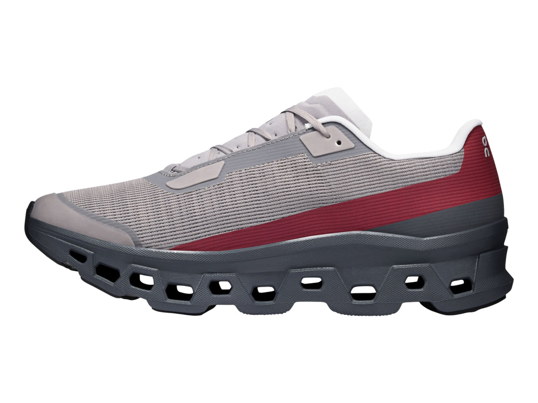 Tenis On Cloud Cloudmonster Void Eclipse para hombre en color gris con franja roja y suela oscura.