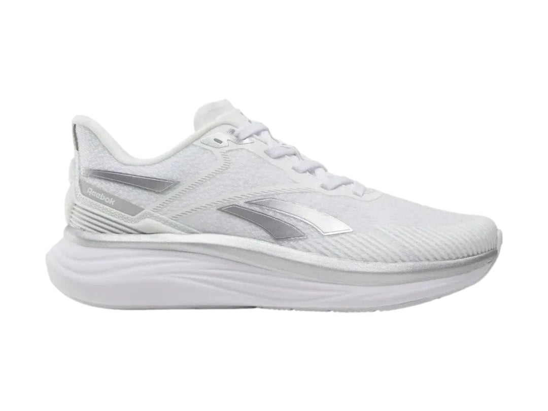 Tenis deportivos Reebok Viva Speed color blanco con detalles plateados, vista lateral.