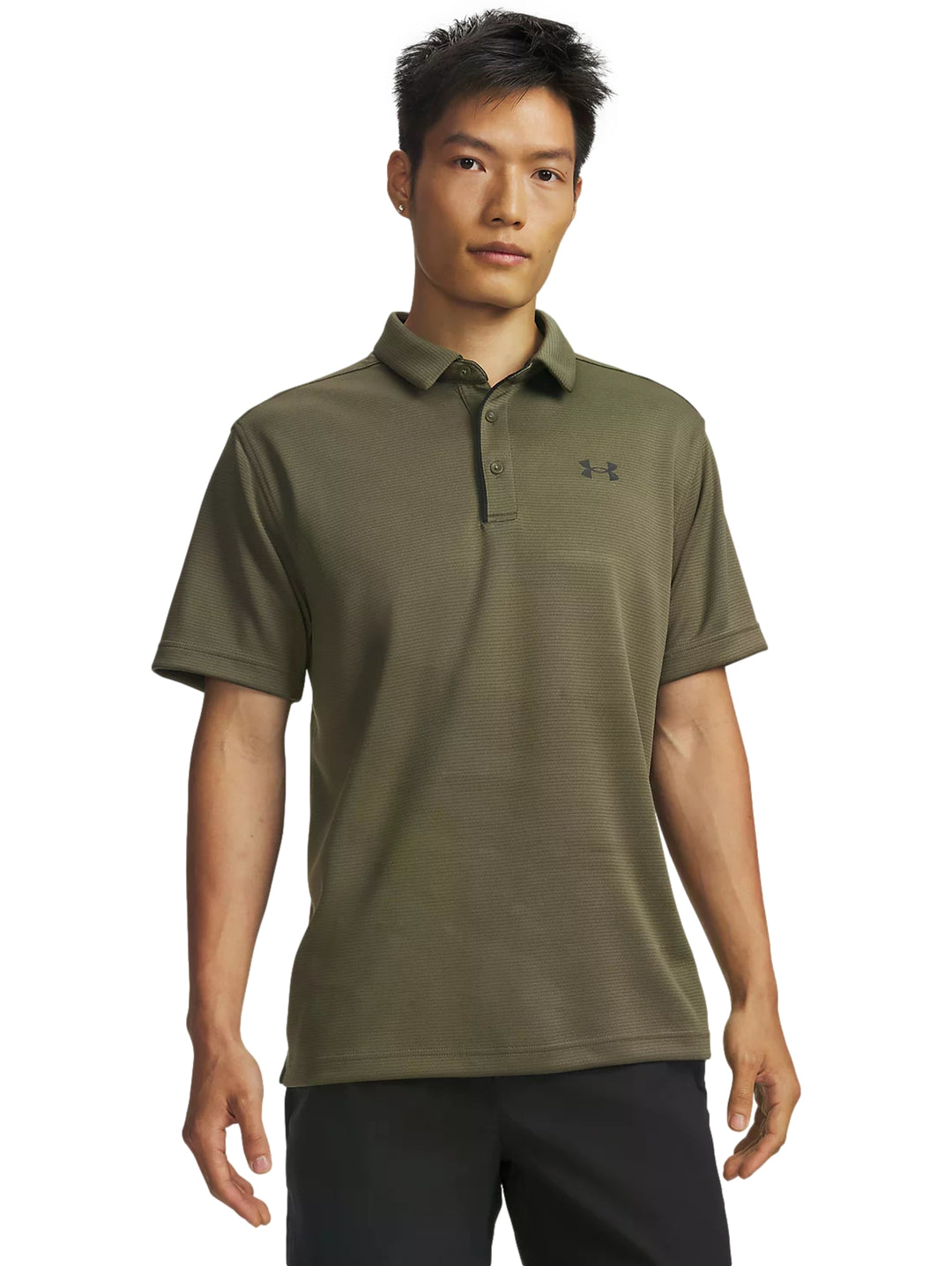Hombre vistiendo playera polo Under Armour de color verde oliva y shorts negros.
