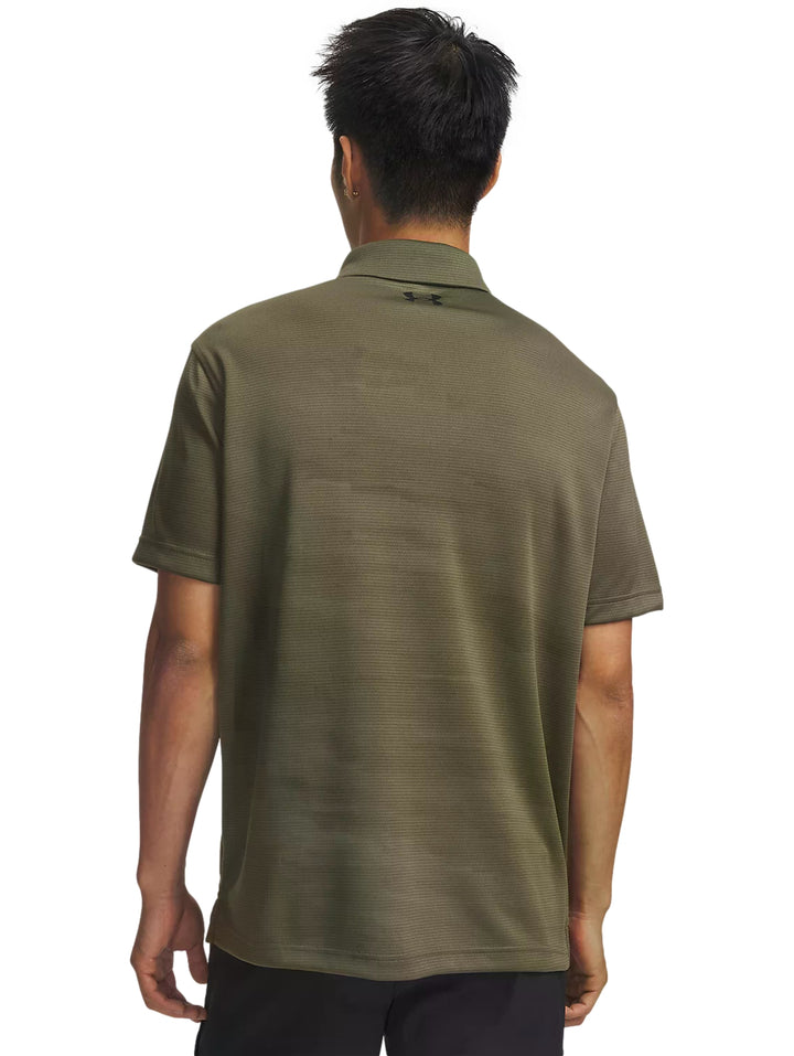 Hombre vistiendo playera polo Under Armour de color verde oliva y shorts negros.