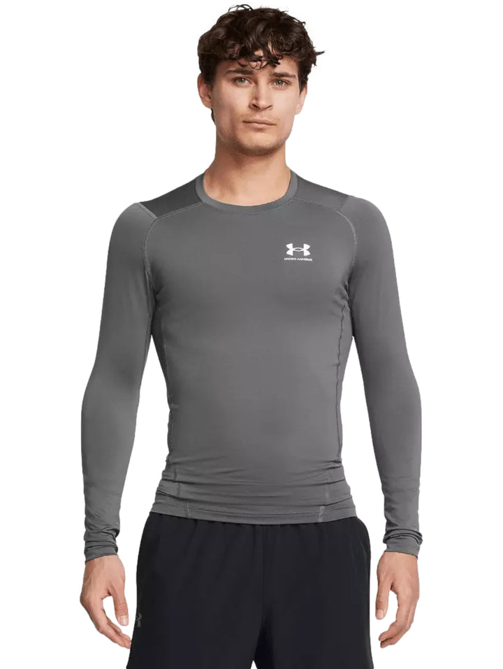 Hombre vistiendo playera deportiva de compresión manga larga color gris de Under Armour.