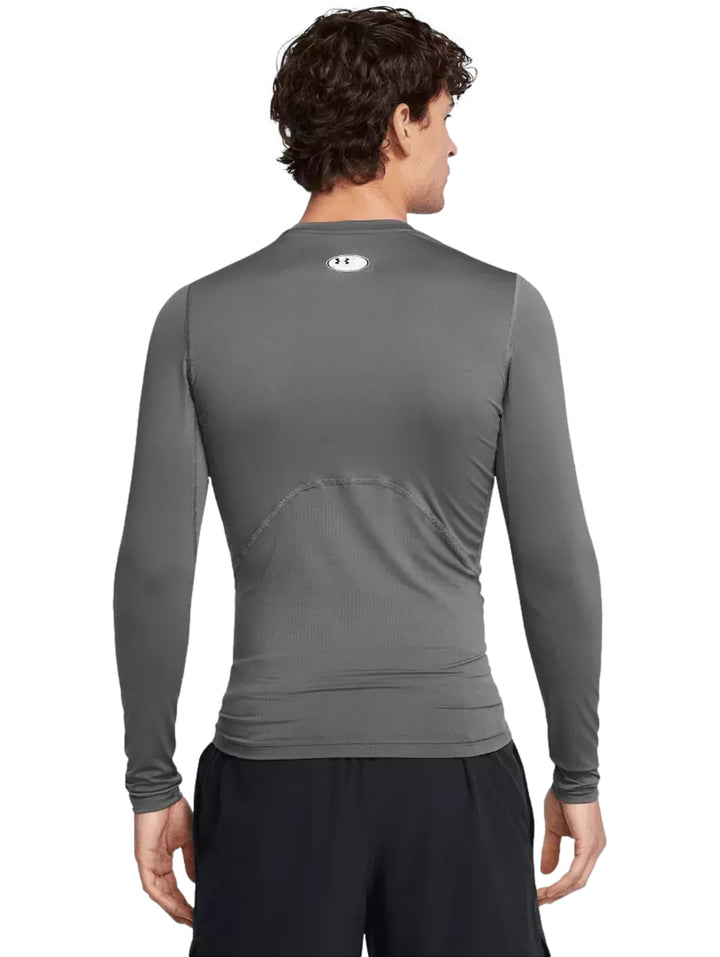 Hombre vistiendo playera deportiva de compresión manga larga color gris de Under Armour.