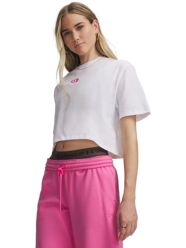 Mujer modelando playera blanca Under Armour de manga corta y pantalones deportivos color rosa.