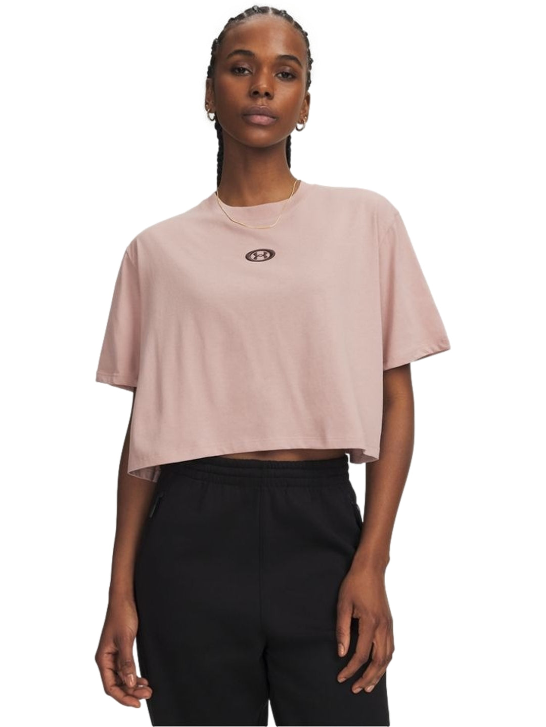 Mujer vistiendo playera rosa Under Armour de manga corta y pantalones negros.