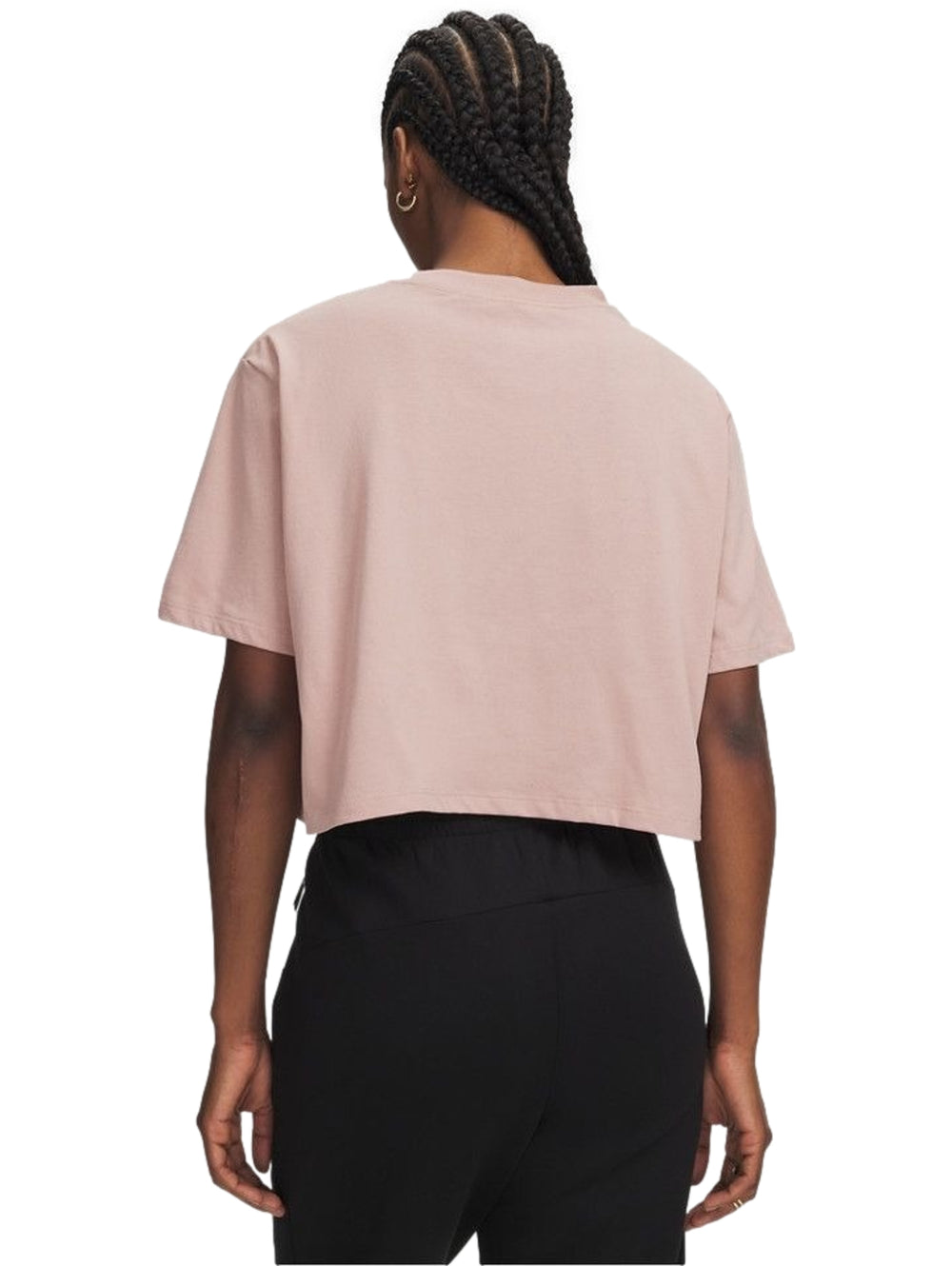 Mujer vistiendo playera rosa Under Armour de manga corta y pantalones negros.
