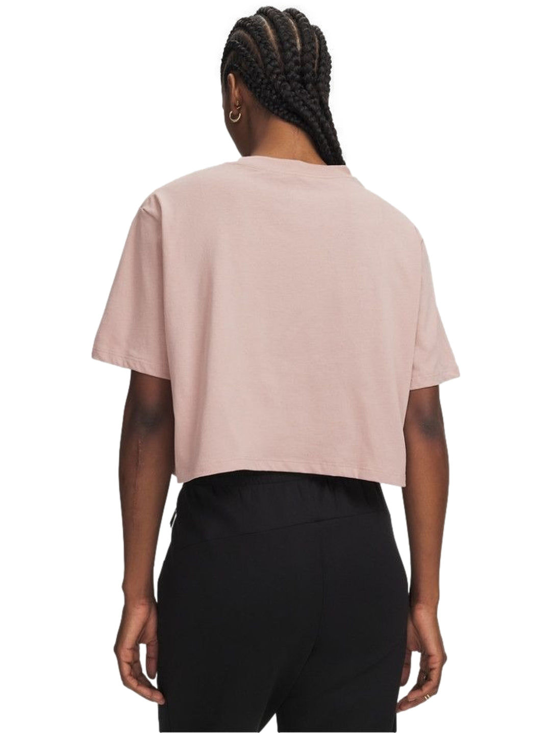 Mujer vistiendo playera rosa Under Armour de manga corta y pantalones negros.