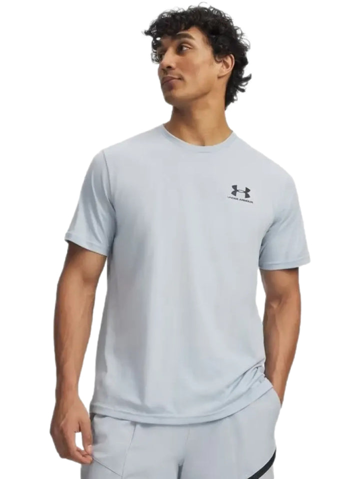 Hombre vistiendo playera deportiva de color gris claro de la marca Under Armour.