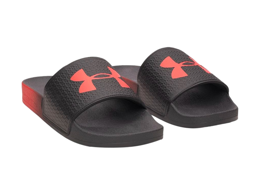 Sandalia Under Armour ARMR Slide color negro con degradado rojo en la suela y logotipo rojo.