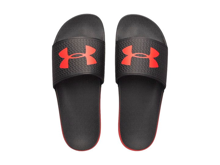 Sandalia Under Armour ARMR Slide color negro con degradado rojo en la suela y logotipo rojo.