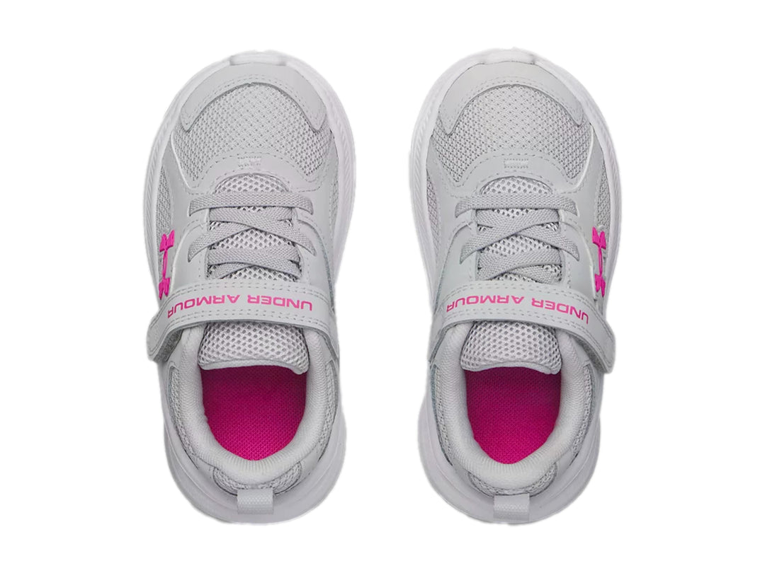 Tenis deportivos Under Armour color gris con suela blanca y detalles en rosa.